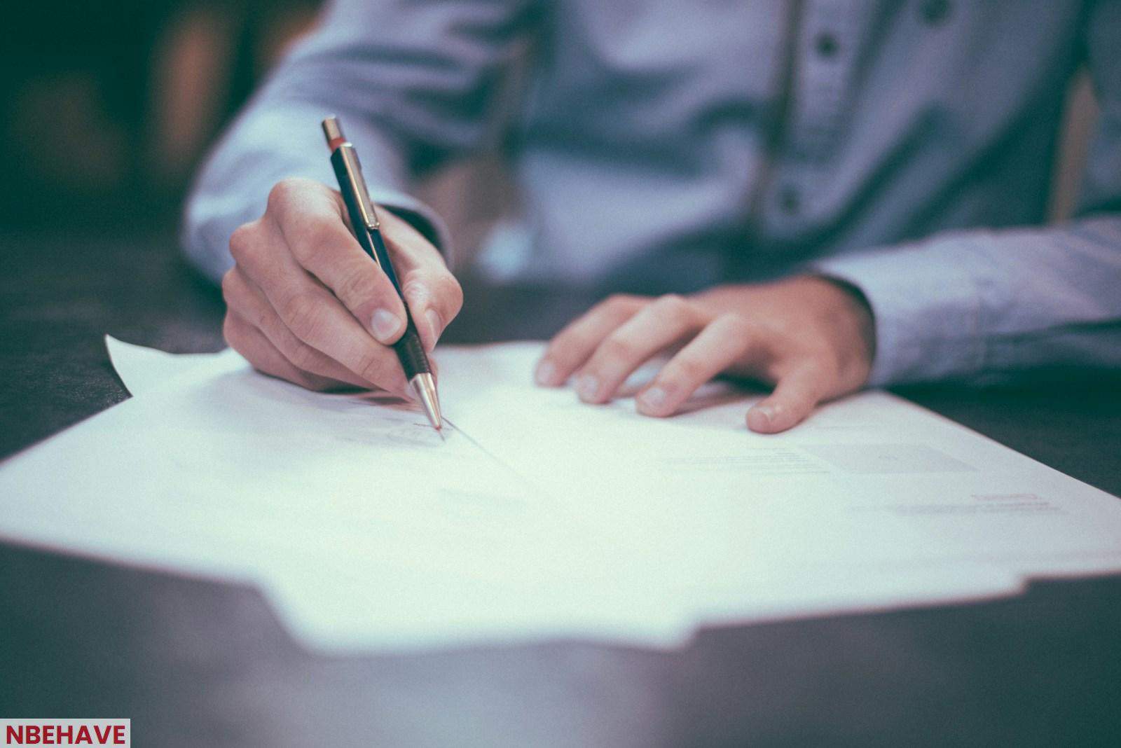 man writing on paper