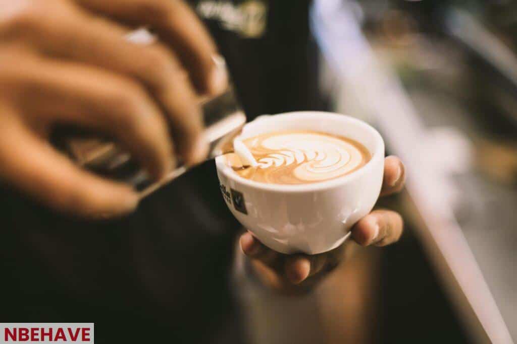 Person Holding White Ceramic Mug Filled With Cappuccino