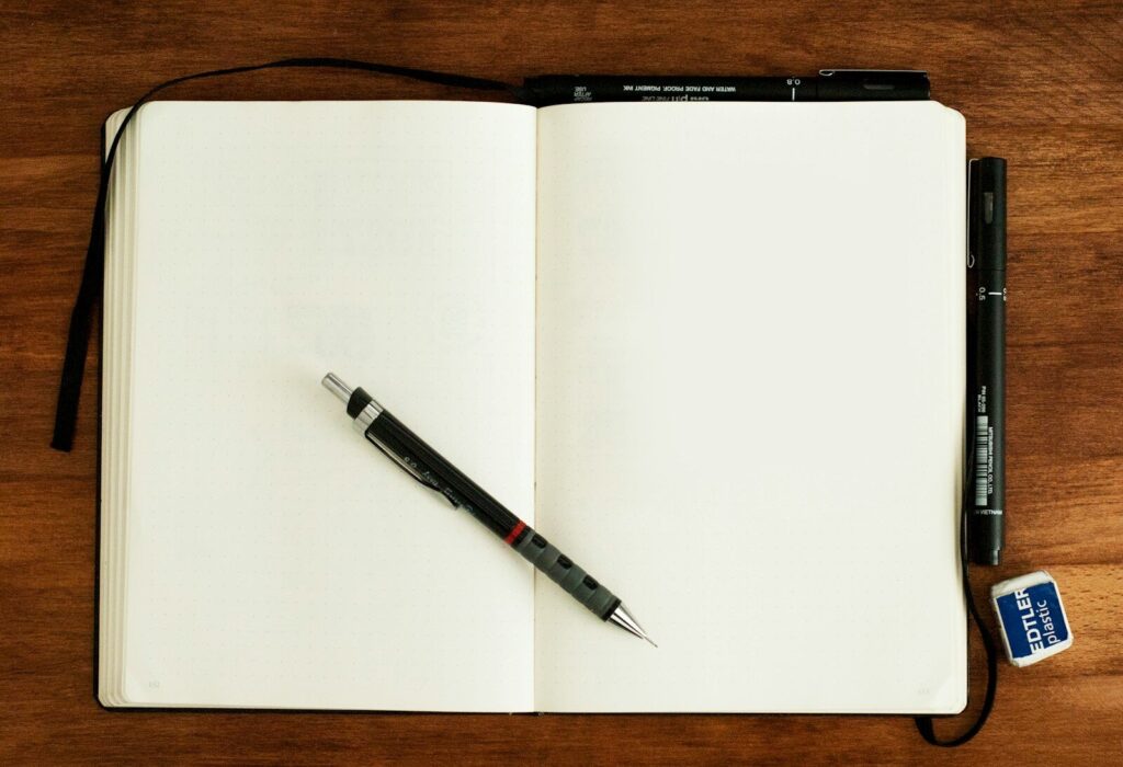 Cuaderno abierto con un bolígrafo sobre una mesa de trabajo